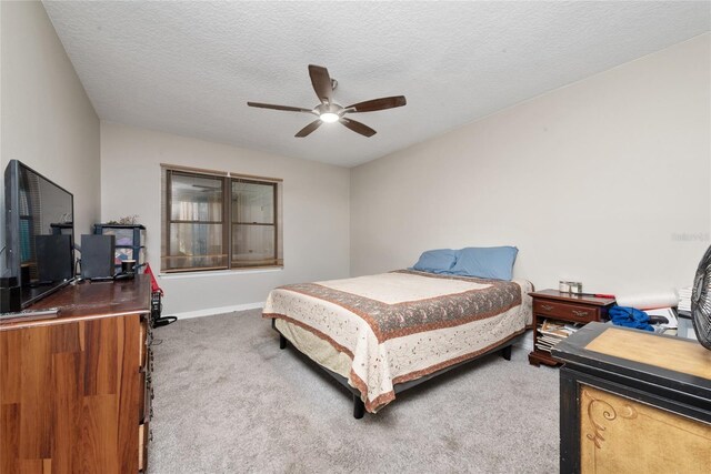 bedroom with ceiling fan, carpet, and a textured ceiling