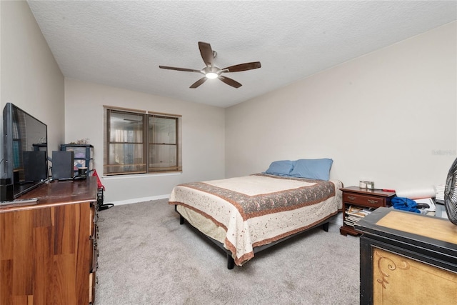 carpeted bedroom with ceiling fan and a textured ceiling