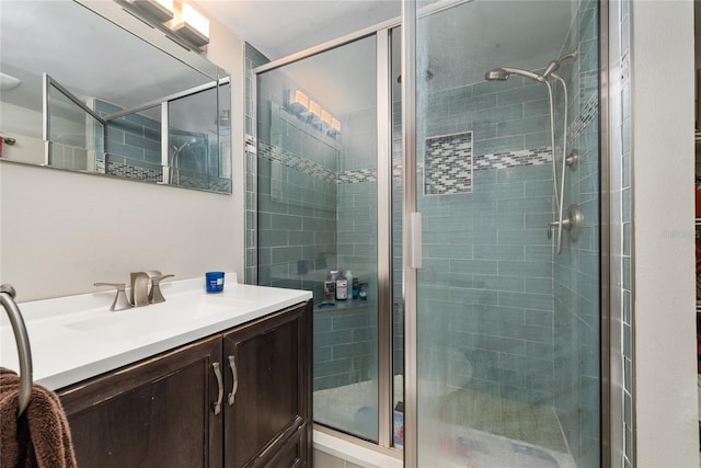 bathroom with a shower with door and vanity