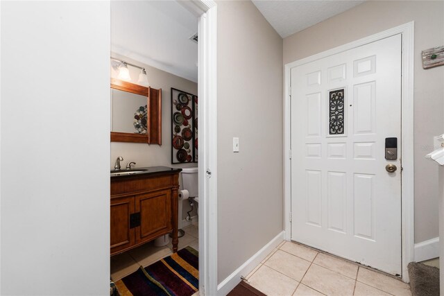 tiled foyer featuring sink