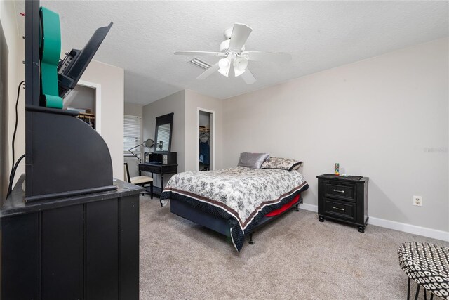 carpeted bedroom with a textured ceiling and ceiling fan