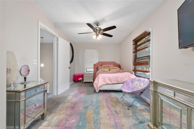 bedroom featuring multiple windows, carpet floors, a textured ceiling, and ceiling fan