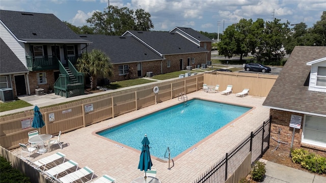 view of swimming pool featuring a patio and central AC