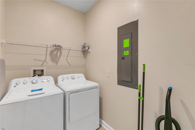 clothes washing area with washing machine and dryer and electric panel