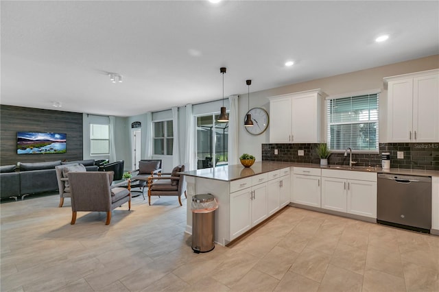 kitchen with sink, dishwasher, white cabinetry, hanging light fixtures, and kitchen peninsula