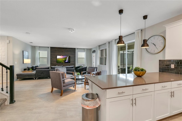 kitchen featuring white cabinetry, decorative light fixtures, and tasteful backsplash