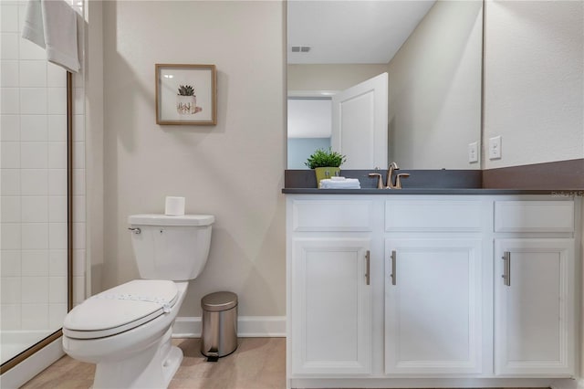 bathroom featuring vanity, toilet, and tiled shower