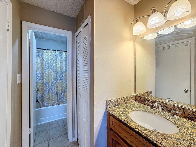 bathroom with tile patterned flooring, vanity, a textured ceiling, and shower / bath combo with shower curtain