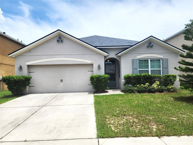 single story home featuring a garage and a front lawn