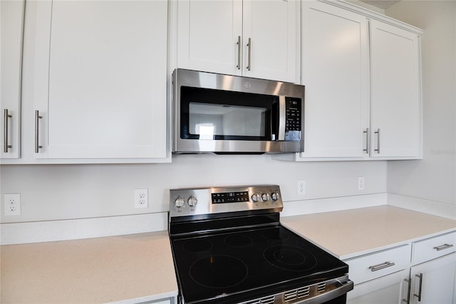 kitchen featuring white cabinetry and appliances with stainless steel finishes