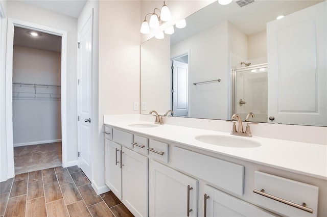 bathroom with an enclosed shower, vanity, and a chandelier