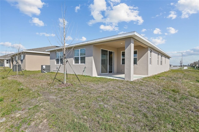 rear view of house featuring a patio, a yard, and central AC unit