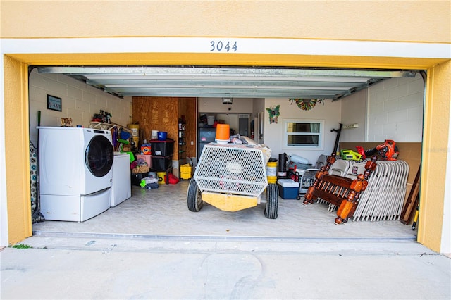 garage featuring washing machine and clothes dryer and refrigerator