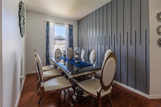 dining area featuring dark hardwood / wood-style flooring and a textured ceiling