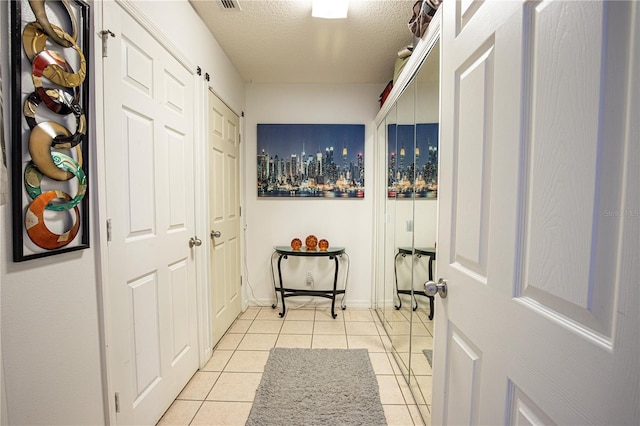 interior space with light tile patterned flooring and a textured ceiling