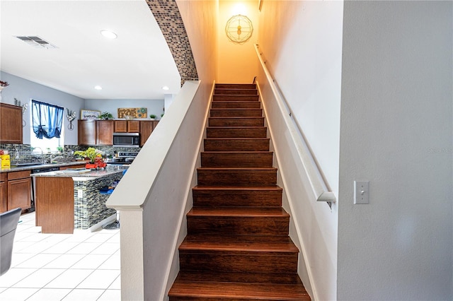 stairs featuring light tile patterned floors