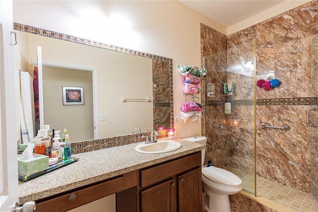 bathroom featuring a shower with door, toilet, and vanity