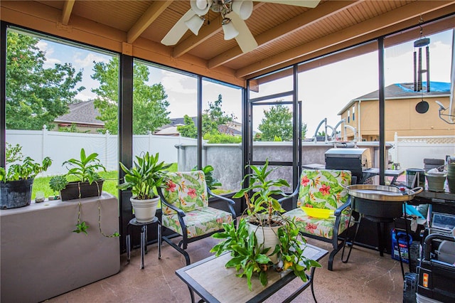 sunroom with beamed ceiling and ceiling fan