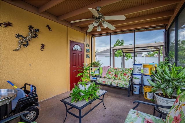 sunroom with beamed ceiling and ceiling fan