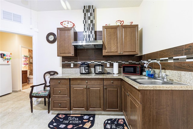 kitchen featuring decorative backsplash, white refrigerator, black microwave, and wall chimney exhaust hood