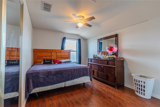 bedroom with a textured ceiling, lofted ceiling, hardwood / wood-style flooring, and ceiling fan