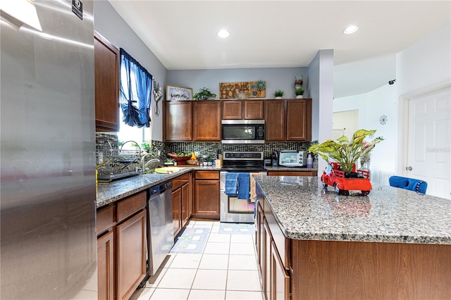 kitchen featuring a center island, light tile patterned floors, backsplash, and stainless steel appliances