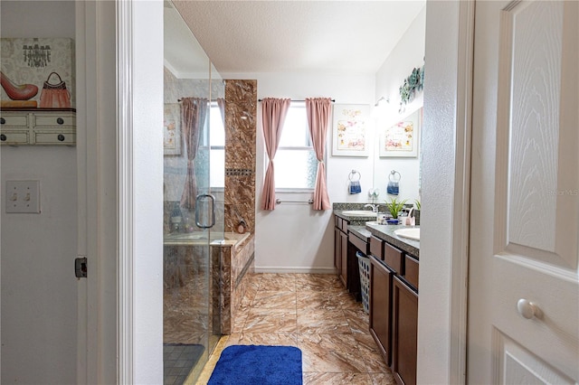 bathroom featuring a shower with shower door, tile patterned flooring, dual bowl vanity, and a textured ceiling