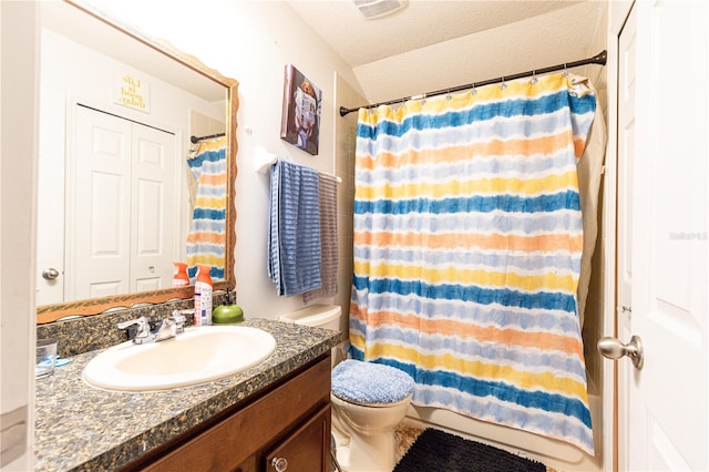 bathroom with vanity, a textured ceiling, and toilet