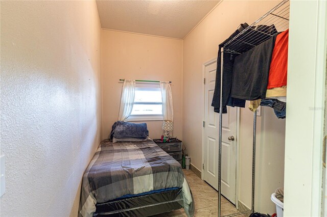 bedroom featuring light tile patterned floors and a textured ceiling