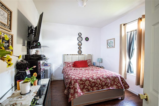 bedroom with dark wood-type flooring