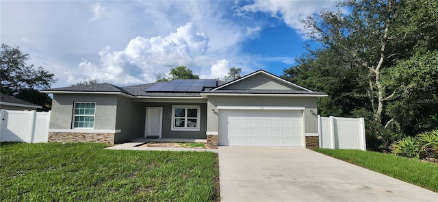 view of front of home with a front yard, solar panels, and a garage