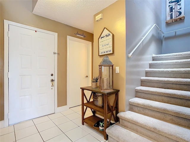 entrance foyer with a textured ceiling and light tile patterned floors