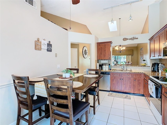 kitchen with stainless steel appliances, light stone countertops, sink, and pendant lighting