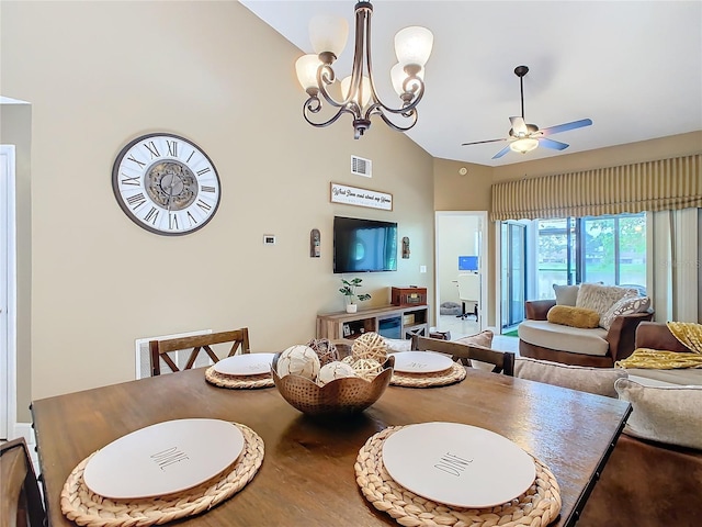 dining area with ceiling fan with notable chandelier and high vaulted ceiling