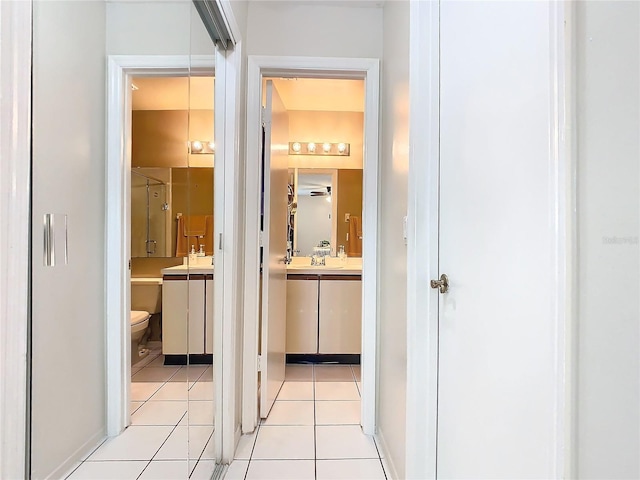 hallway featuring light tile patterned floors and sink