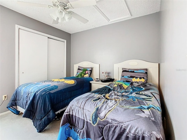 carpeted bedroom featuring a textured ceiling, a closet, and ceiling fan