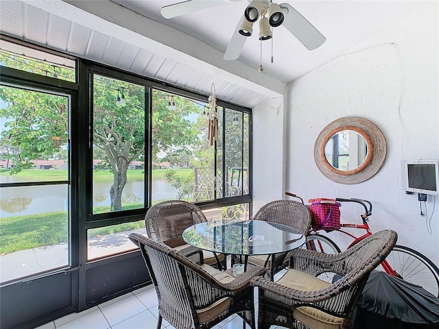 sunroom / solarium with ceiling fan and a water view