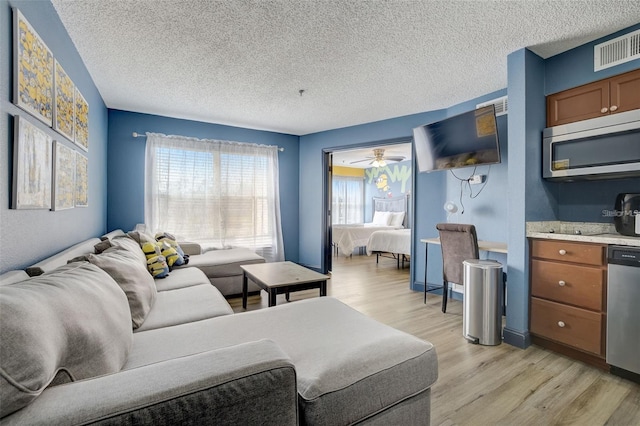 living room featuring a textured ceiling and light hardwood / wood-style floors