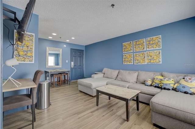 living room with light hardwood / wood-style floors and a textured ceiling