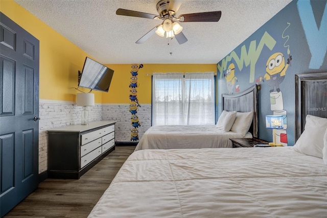 bedroom featuring ceiling fan, dark hardwood / wood-style floors, and a textured ceiling