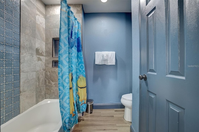 bathroom featuring hardwood / wood-style floors, shower / bath combination with curtain, and toilet