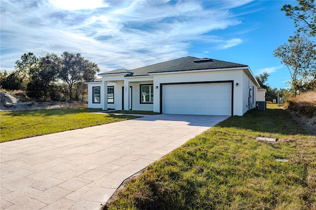 ranch-style house featuring a garage, central air condition unit, and a front lawn