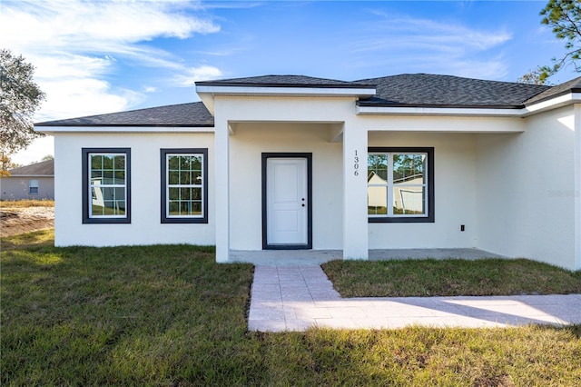 view of exterior entry featuring a lawn