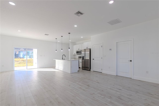 unfurnished living room featuring sink and light wood-type flooring