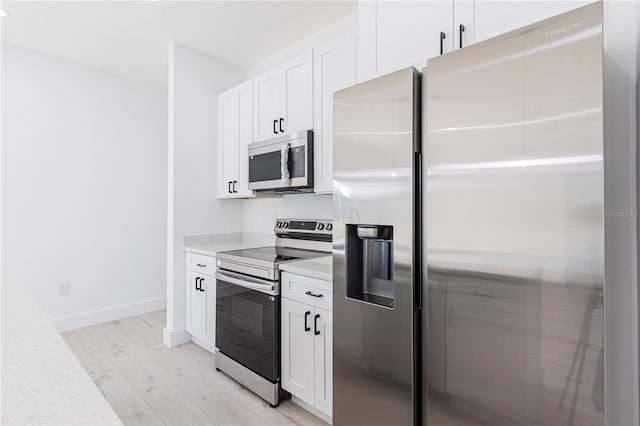 kitchen featuring white cabinets, light hardwood / wood-style floors, and stainless steel appliances