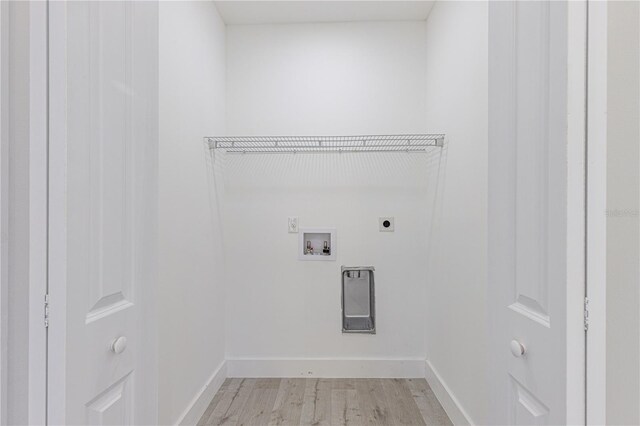 laundry area with electric dryer hookup, hookup for a washing machine, and light hardwood / wood-style floors