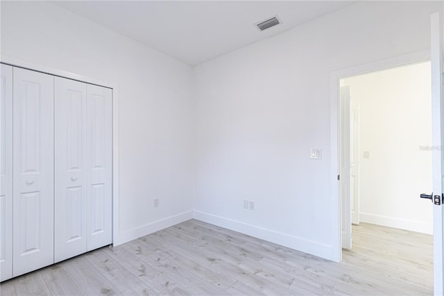 unfurnished bedroom featuring light wood-type flooring and a closet