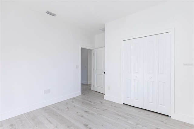 unfurnished bedroom with a closet and light hardwood / wood-style flooring