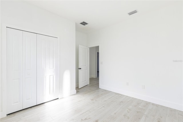 unfurnished bedroom featuring a closet and light hardwood / wood-style flooring