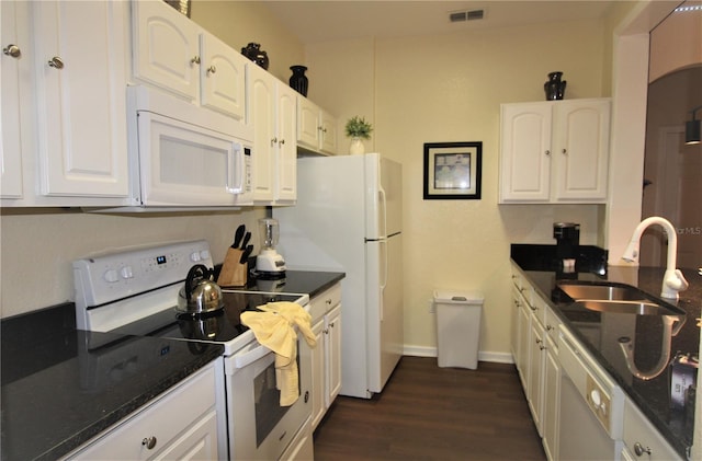 kitchen featuring dark stone counters, white appliances, white cabinets, sink, and dark wood-type flooring